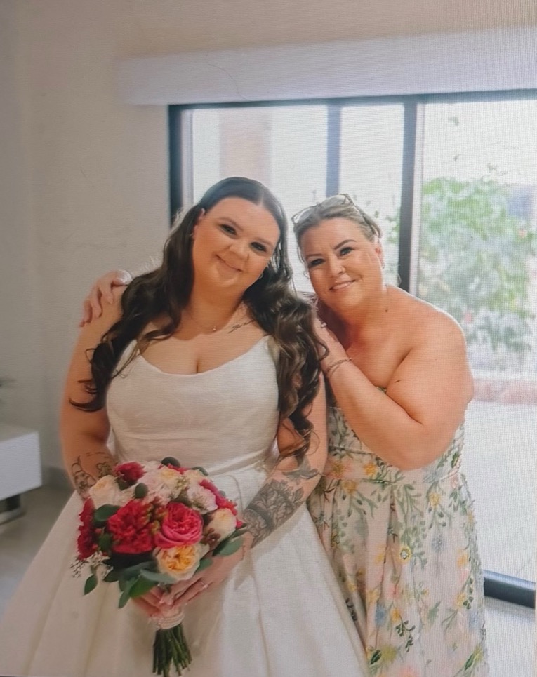 A bride holding her bouquet with her mother