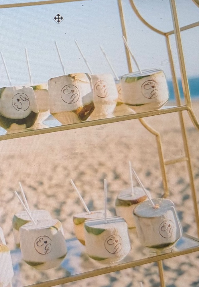 Coconut drinks on a gold stand at a beach celebration